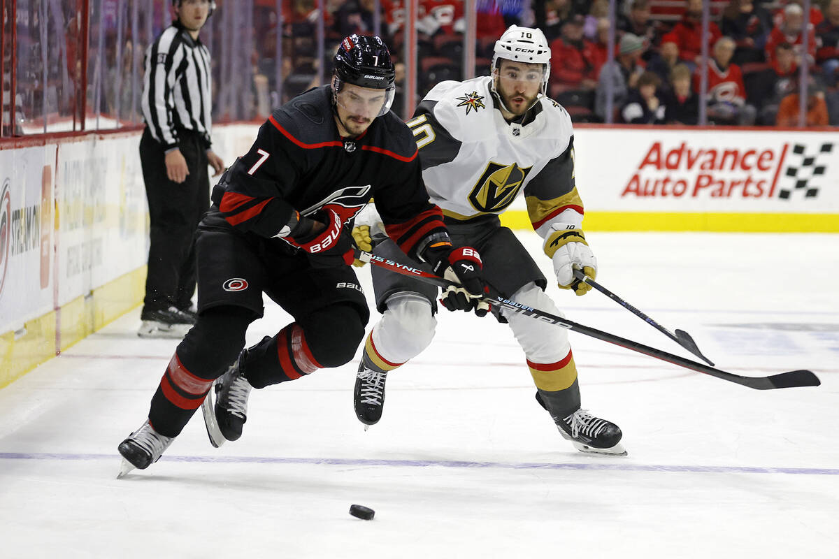 Carolina Hurricanes' Dmitry Orlov (7) and Vegas Golden Knights' Nicolas Roy (10) chase after th ...