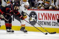 Vegas Golden Knights' Nicolas Roy (10) protects the puck from Carolina Hurricanes' Jesper Fast ...