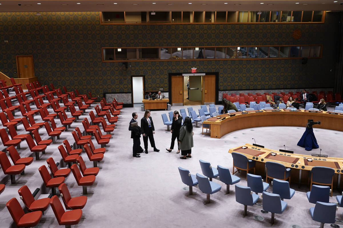People stand in the mostly empty Security Council chambers at United Nations headquarters, Thur ...