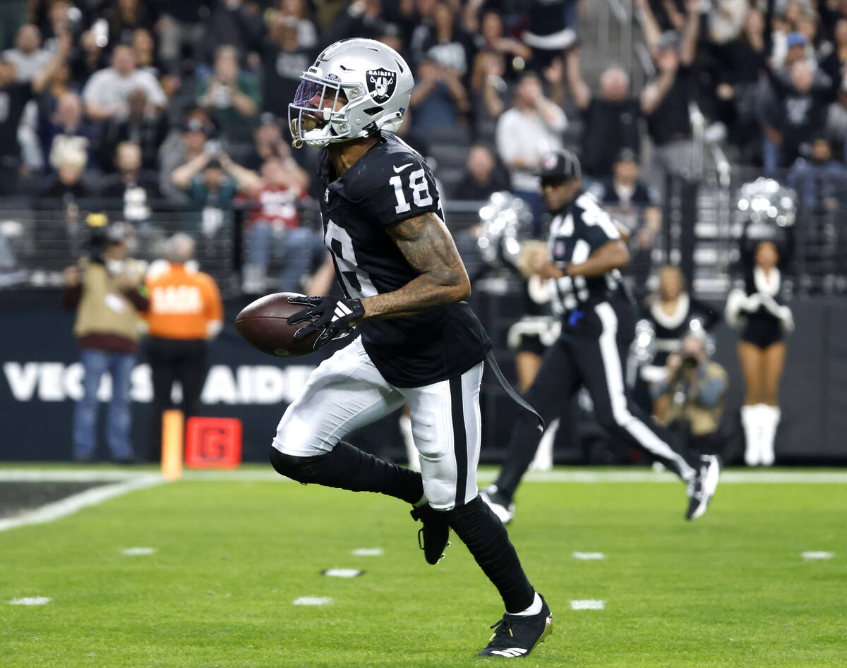 Raiders cornerback Jack Jones (18) scores a touchdown after intercepting a pass from Los Angele ...