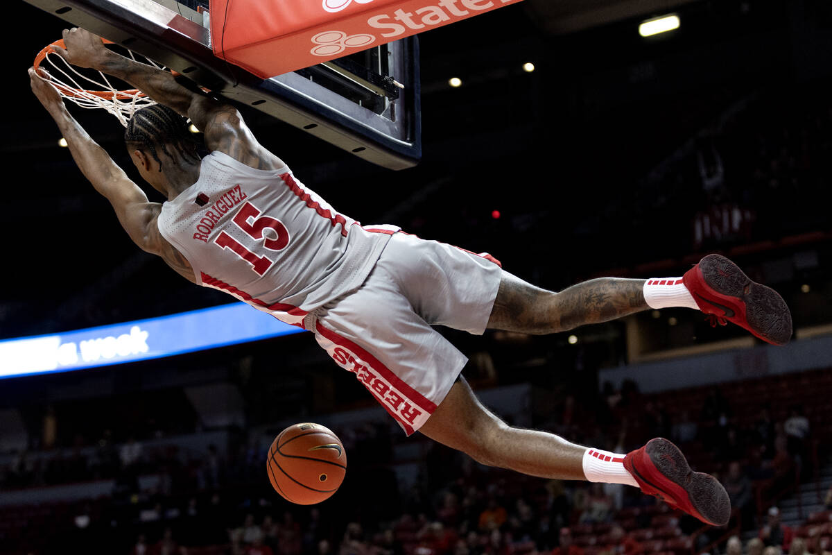 UNLV Rebels guard Luis Rodriguez (15) hangs on the rim after dunking during the second half of ...