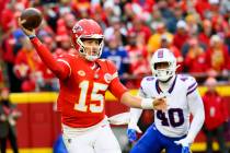 Kansas City Chiefs quarterback Patrick Mahomes (15) throws while being chased by Buffalo Bills ...