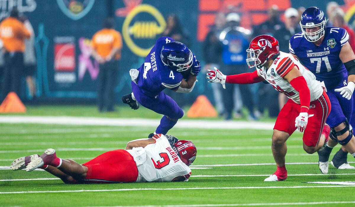 Northwestern Wildcats running back Cam Porter (4) is tackled by Utah Utes running back Ja'Quind ...