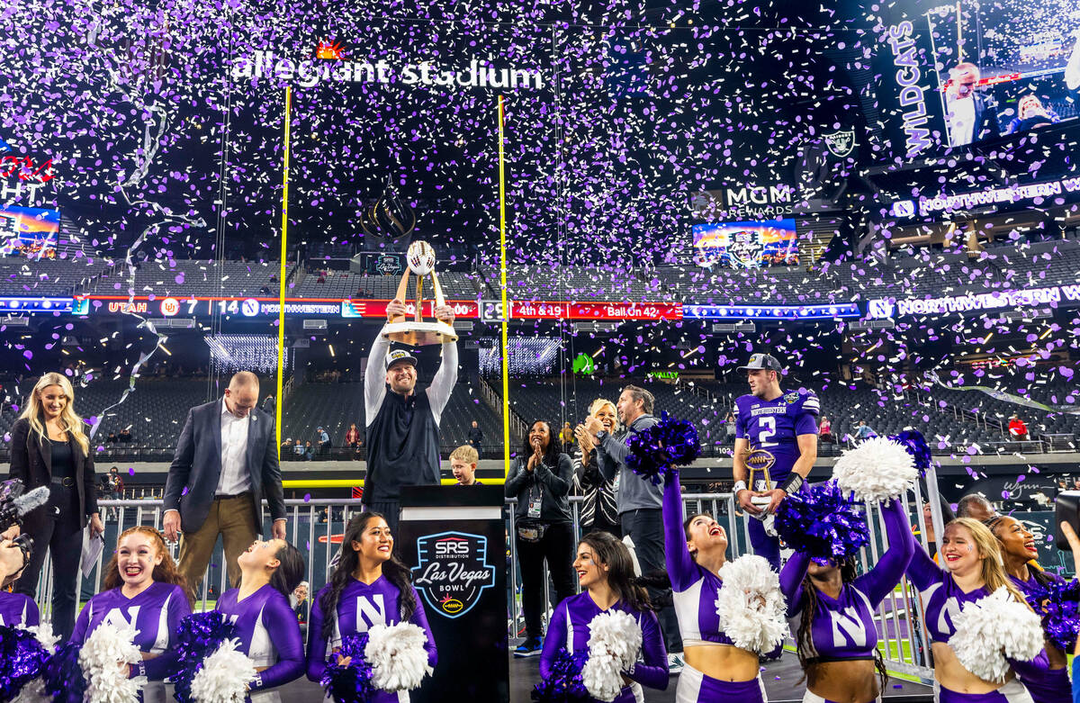 Northwestern Wildcats head coach David Braun celebrates their win with the trophy overhead beat ...