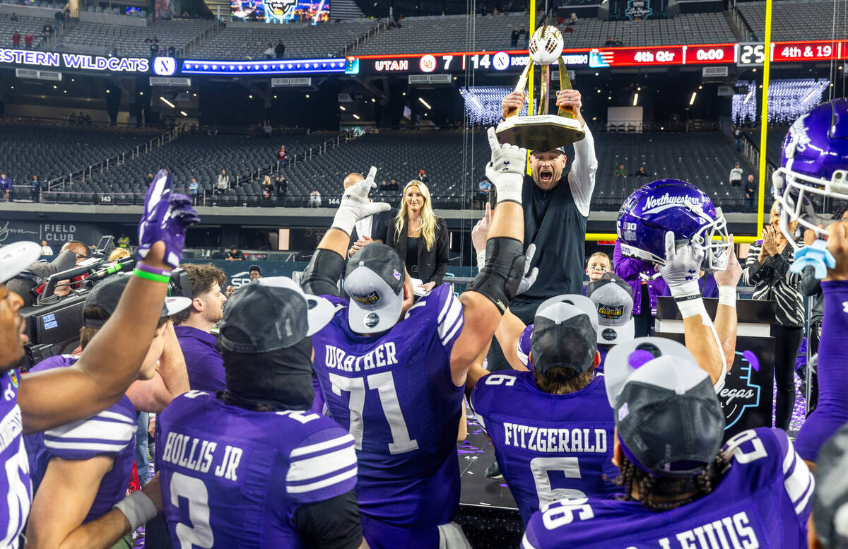 Northwestern Wildcats head coach David Braun celebrates their win with the trophy overhead beat ...