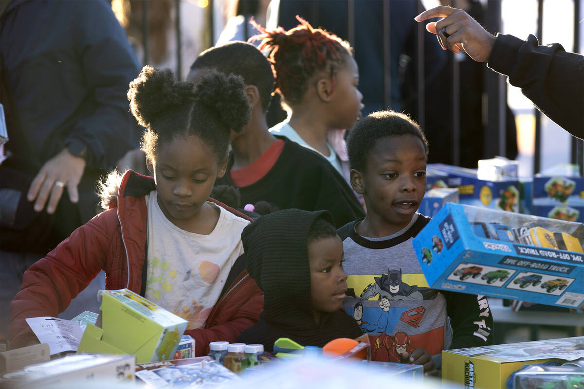 Kids looks for a free toy during a Christmas block party organized by Take Back the Block and M ...