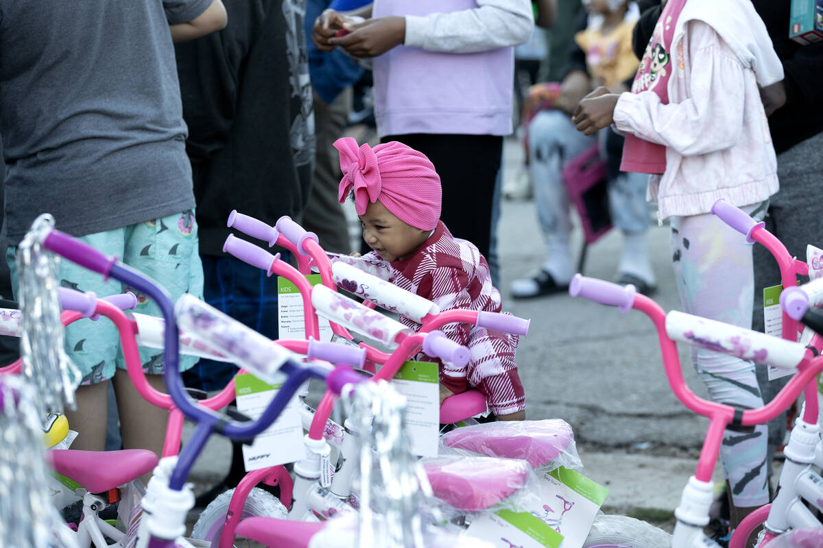 A little one gets excited at bikes for raffle during a Christmas block party organized by Take ...