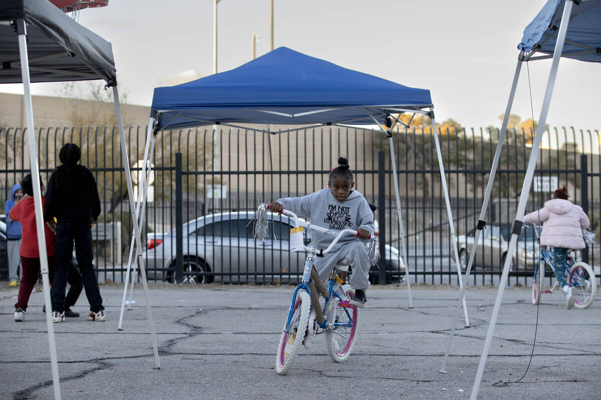Kids play with their new bikes and toys during a Christmas block party organized by Take Back t ...
