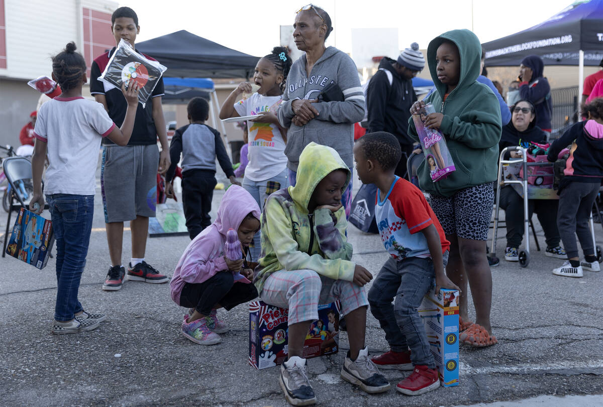 Kids show off their new toys during a Christmas block party organized by Take Back the Block an ...