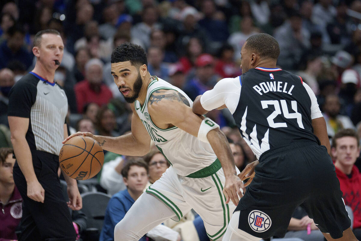 Boston Celtics forward Jayson Tatum (0) drives against Los Angeles Clippers guard Norman Powell ...