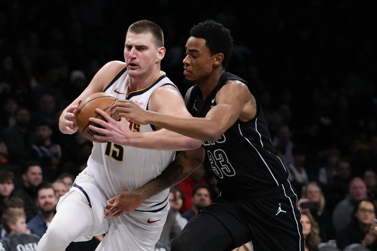 Denver Nuggets' Nikola Jokic (15) drives past Brooklyn Nets' Nic Claxton (33) during the first ...