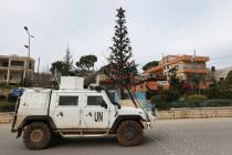A U.N peacekeeper vehicle passes next of a Christmas tree that set in Marjayoun square, a town ...