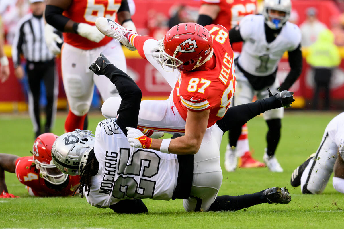 Kansas City Chiefs tight end Travis Kelce (87) is tackled by Las Vegas Raiders safety Tre'von M ...
