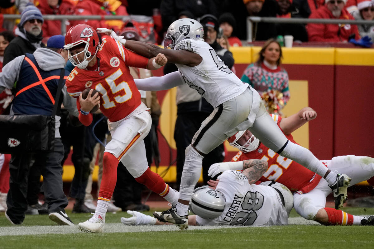 Kansas City Chiefs quarterback Patrick Mahomes (15) is pushed out of bounds by Las Vegas Raider ...