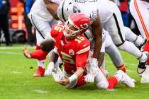 Kansas City Chiefs quarterback Patrick Mahomes (15) recovers his own fumble while being tackled ...