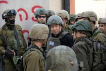 Israeli Prime Minister Benjamin Netanyahu, center, wears a protective vest and helmet as he rec ...