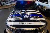 A patrol vehicle has a dedication on its hood during a candlelight vigil for Nevada Highway Pat ...