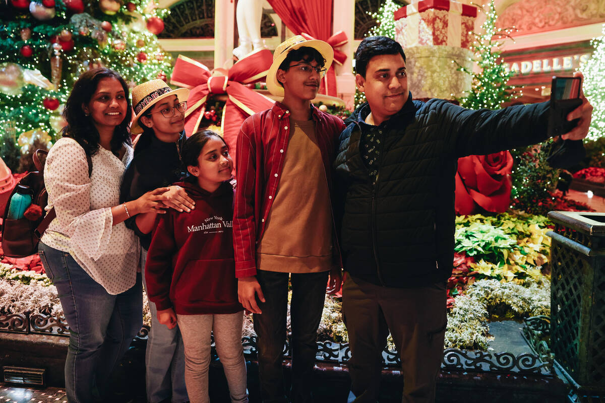 A family takes a selfie together inside of the Bellagio Conservatory on Sunday, Dec. 31, 2023, ...