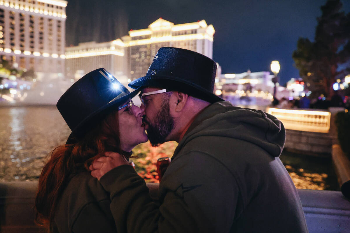 Maria Ferrera, left, and Frank Suarez kiss as the Bellagio Fountains finish going off on Sunday ...