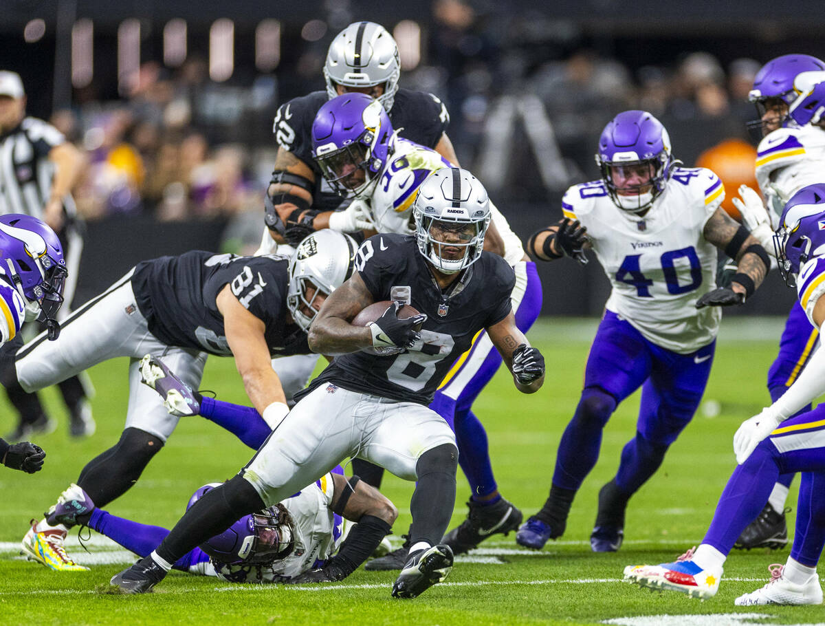 Raiders running back Josh Jacobs (8) looks for more yardage against the Minnesota Vikings durin ...