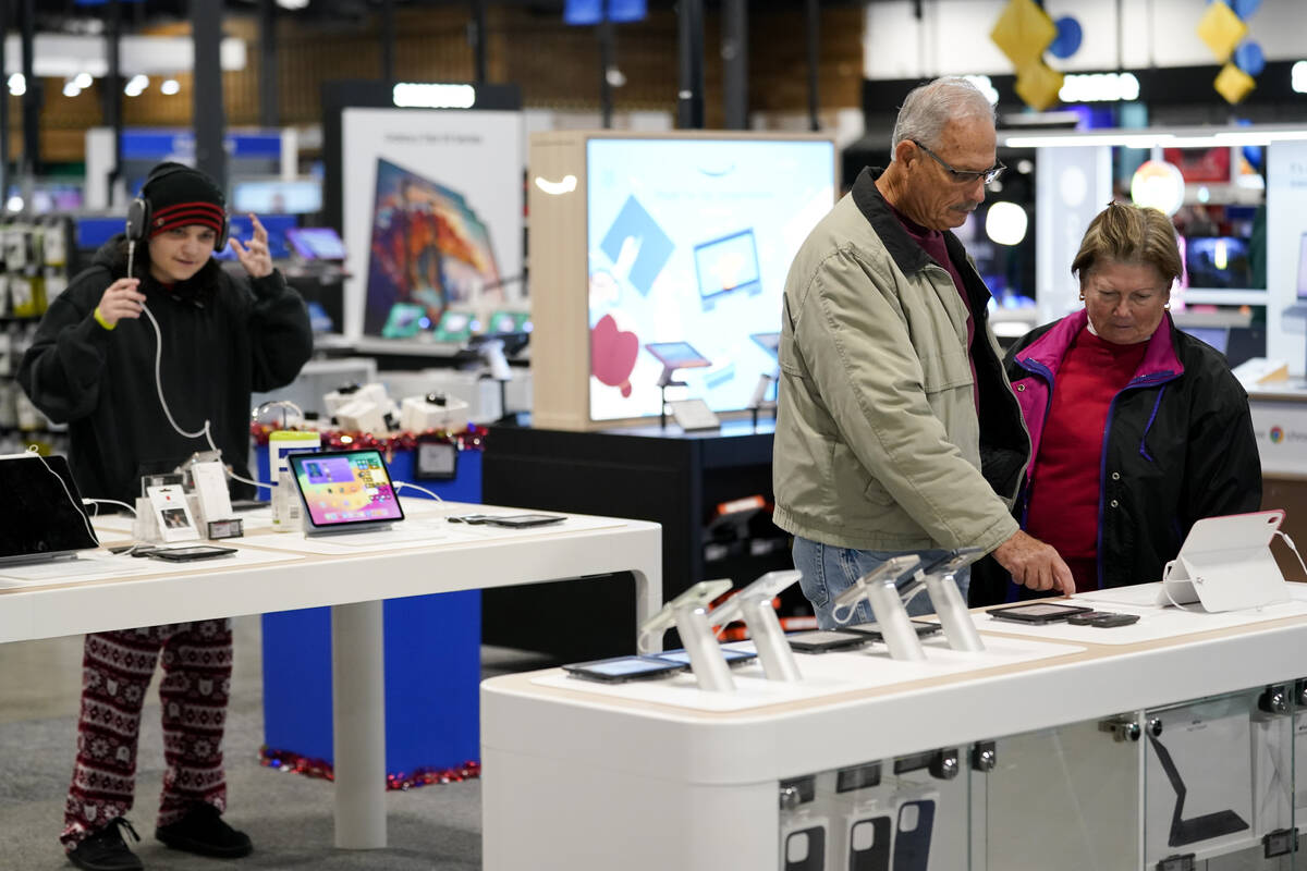 Bob Adkison, center, and his wife Rosie, right, browse computer tablets at a Best Buy store, Fr ...