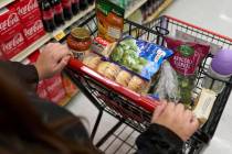 A food shopper pushes a cart of groceries at a supermarket in Bellflower, Calif., on Monday, Fe ...