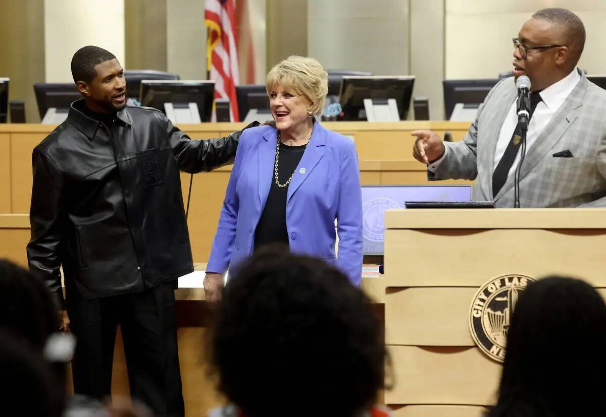 Usher, a la izquierda, abraza a la alcaldesa de Las Vegas Carolyn Goodman mientras el concejal ...