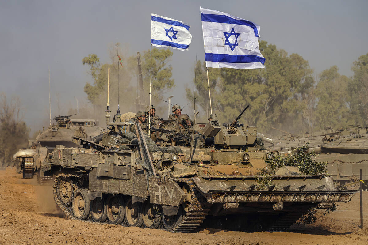 Israeli army vehicles arrive to an staging area after combat in the Gaza Strip in southern Isra ...