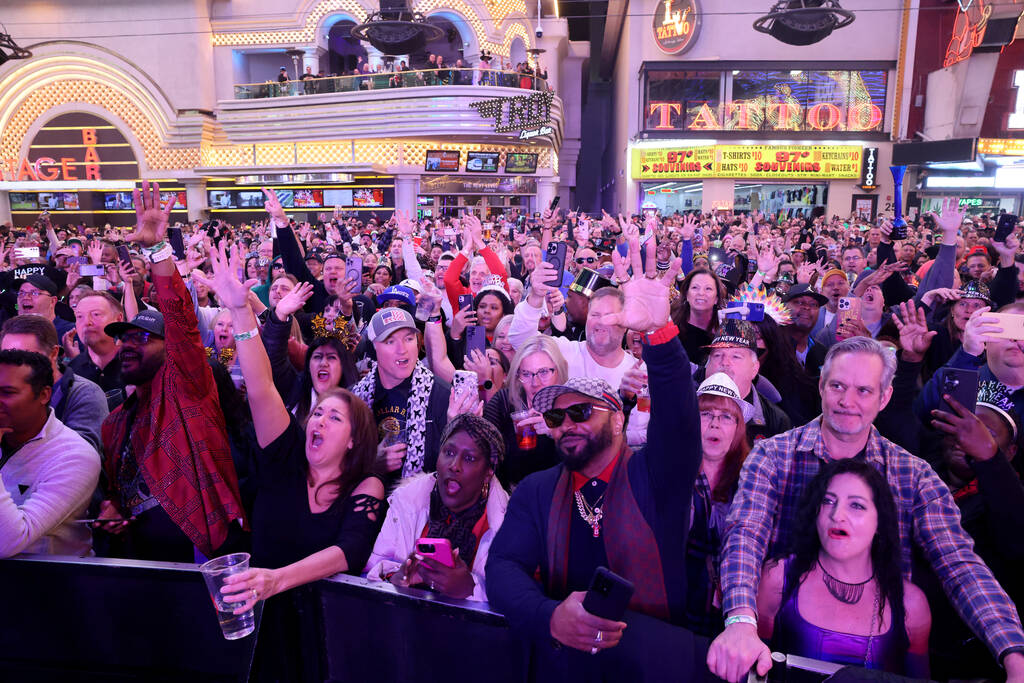 New Year’s Eve revelers listen to Color Me Badd on the First Street Stage during the Tim ...