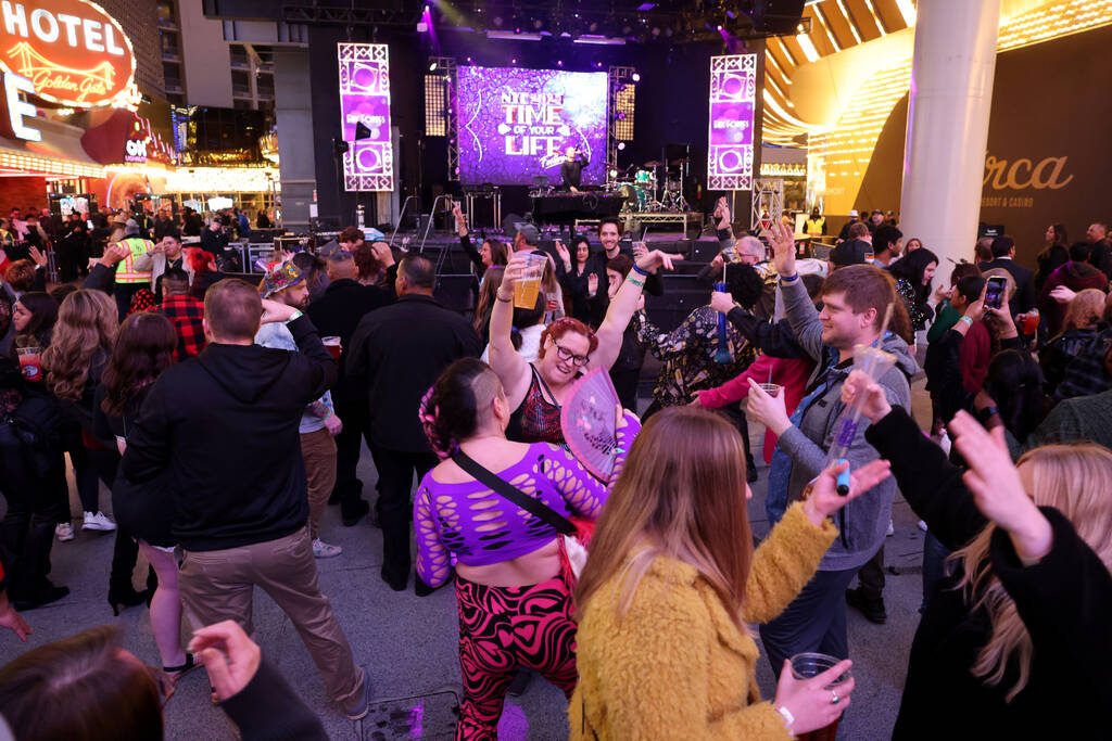 New Year’s Eve revelers dance at the Main Street Stage during the Time of Your Life Fest ...