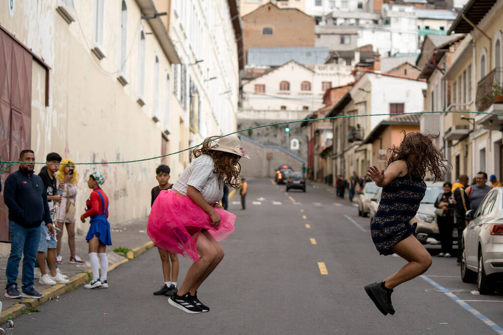 Men dressed as widows jump the rope while waiting for drivers to pass, asking for money to buy ...