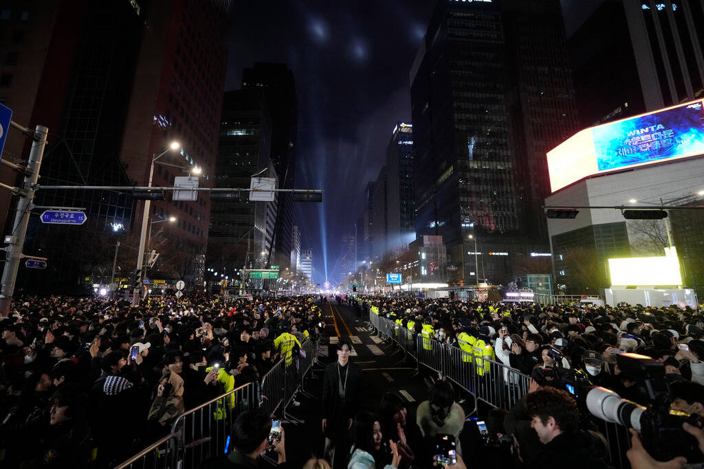 People celebrate New Year's in front of the Bosingak pavilion where its annual New Year's bell- ...