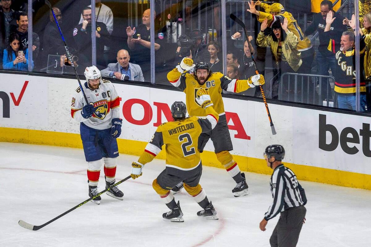 Golden Knights right wing Mark Stone (61) celebrates his first goal with defenseman Zach Whitec ...