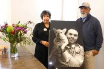 Tonnie Bivens and his wife, Susan Hernandez, pose with a photograph of their son Dr. Aaron Bive ...