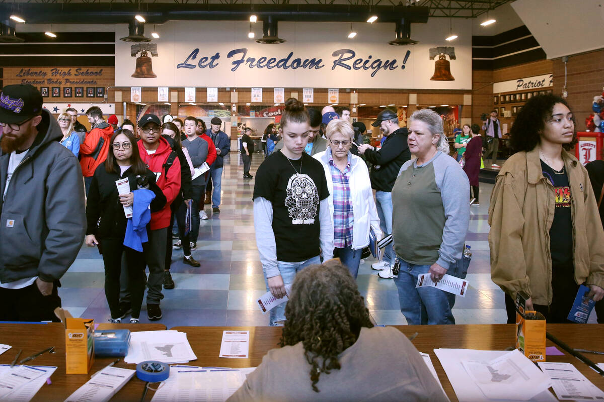 Democratic caucus-goers sign in at the caucus site at Liberty High School on Saturday, Feb. 22, ...