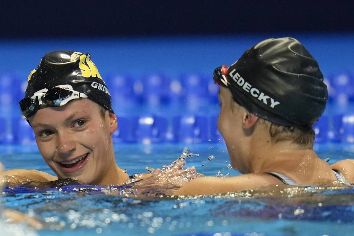 FILE - Katie Ledecky congratulates Katie Grimes after the women's 800 freestyle during wave 2 o ...