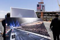 Construction crews hoist a barrier, right, during a topping off ceremony for the Formula One La ...