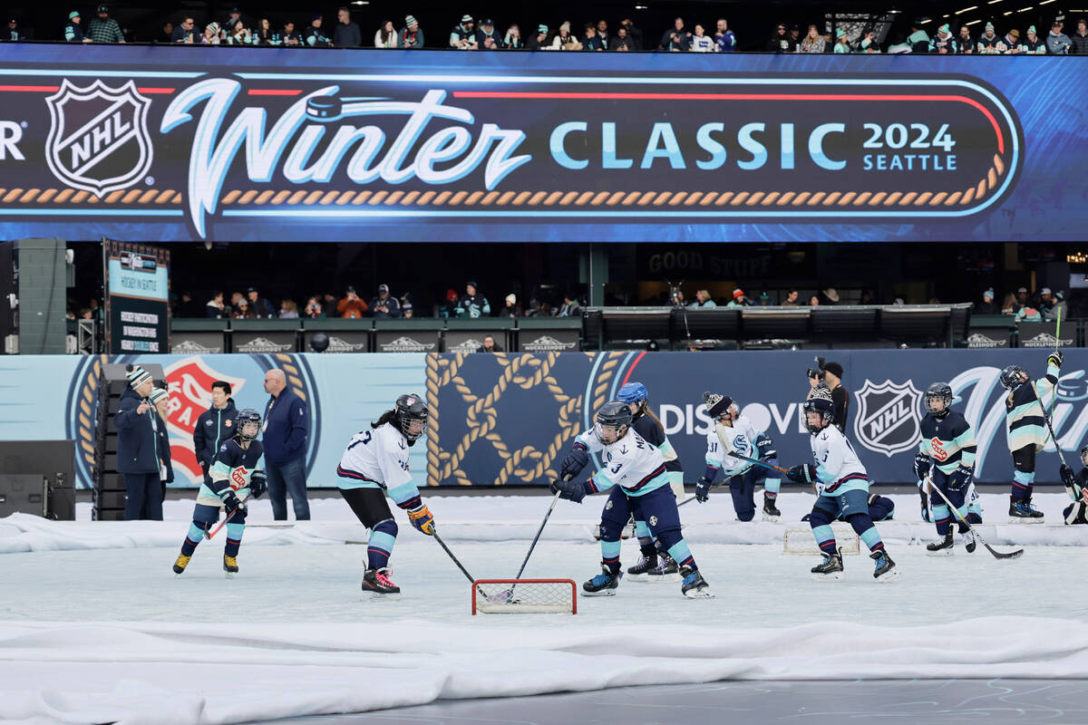 Children play on a miniature rink before the NHL Winter Classic hockey game between the against ...