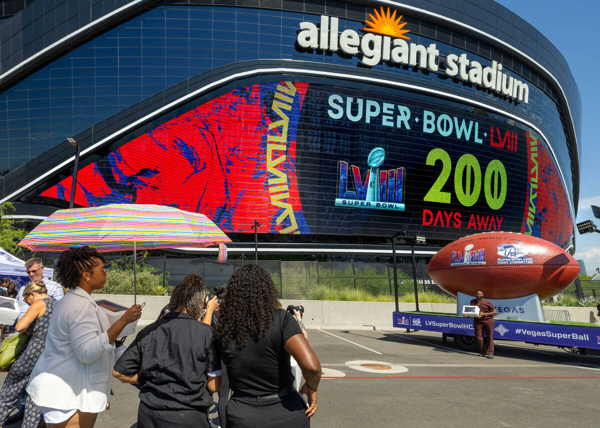 Jeremy Washington, right, of Mr. Jeremy's Grand Delights, has his photo taken by the Super Ball ...