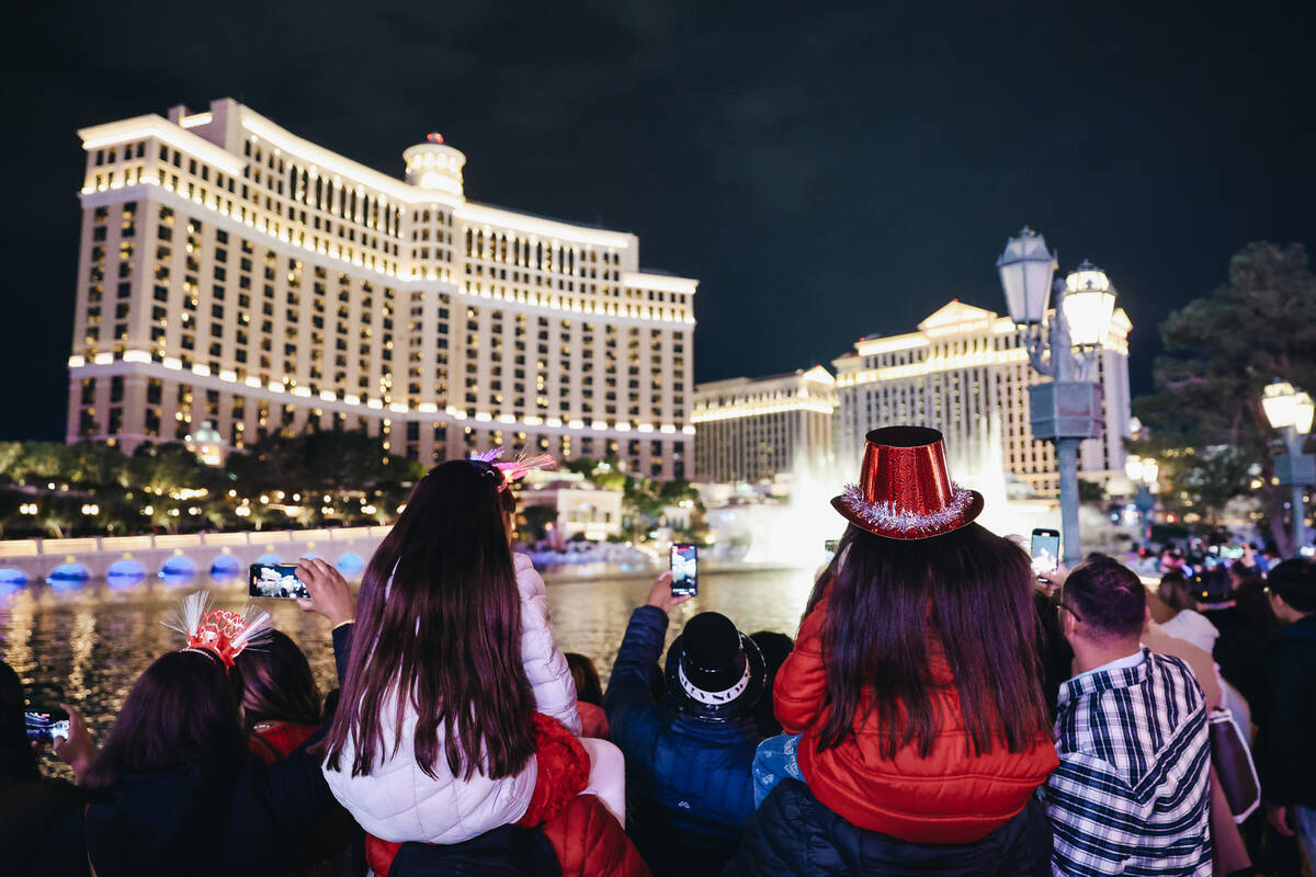 Children watch the Bellagio fountains go off on Sunday, Dec. 31, 2023, in Las Vegas. (Madeline ...