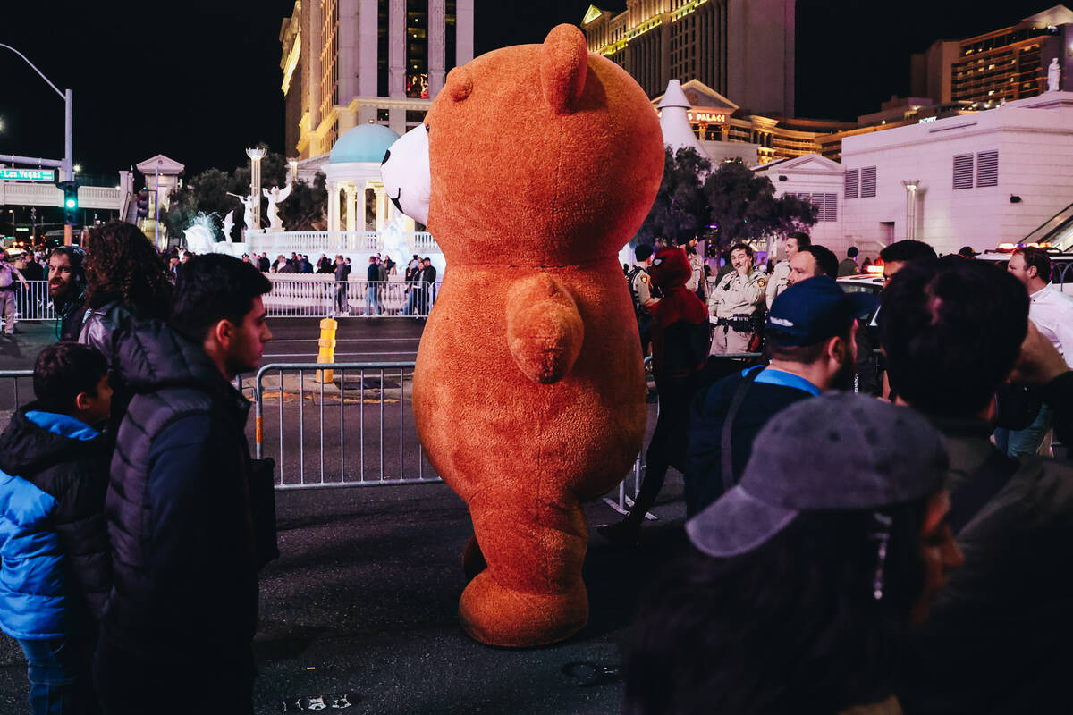 A giant teddy bear was past pedestrians on Sunday, Dec. 31, 2023, in Las Vegas. (Madeline Carte ...