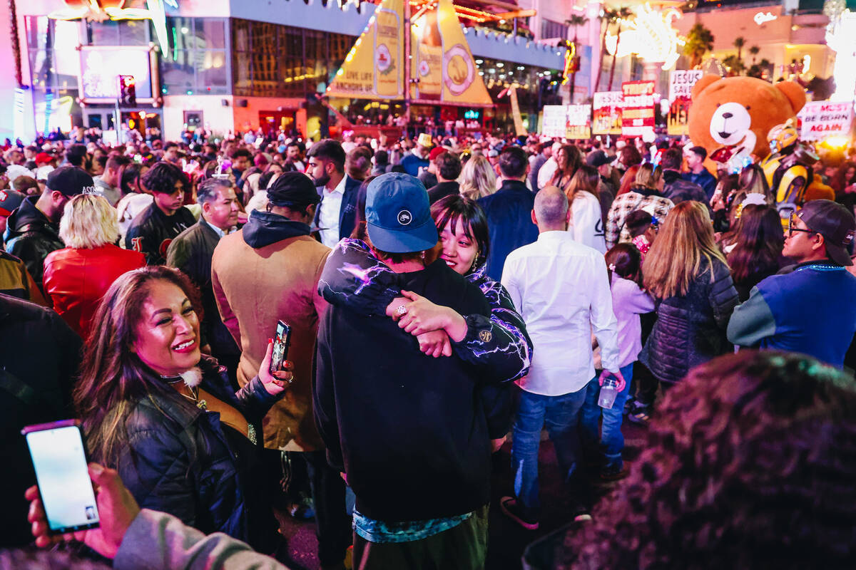 A couple hugs as crowds form on the Strip shortly before midnight on Sunday, Dec. 31, 2023, in ...