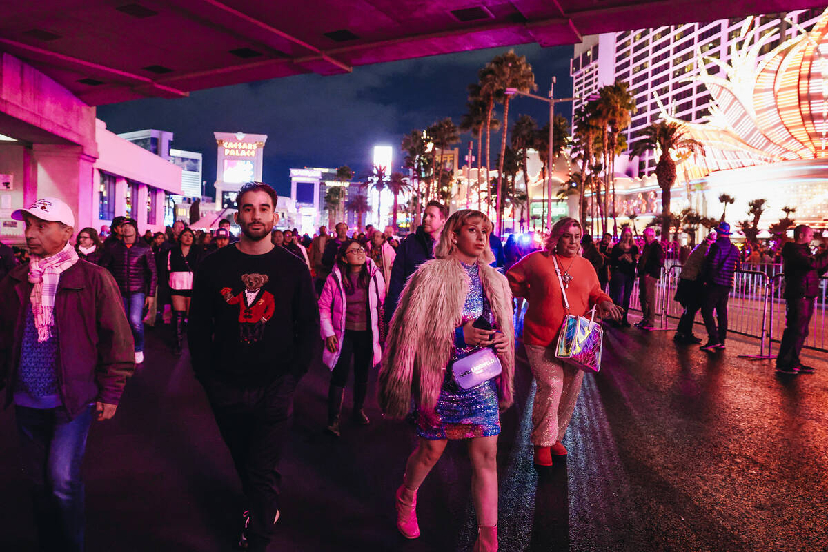 New Year’s revelers walks the Strip on Sunday, Dec. 31, 2023, in Las Vegas. (Madeline Ca ...