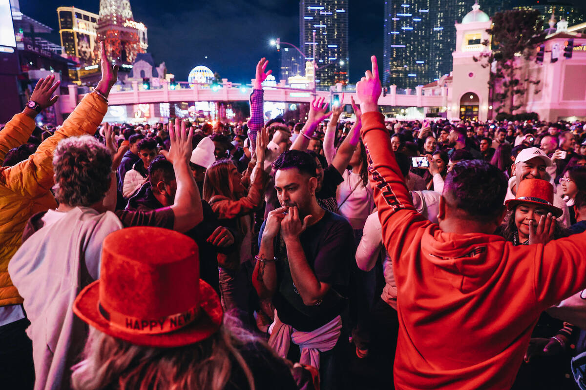 New Year’s revelers dance in the middle of the Strip on Sunday, Dec. 31, 2023, in Las Ve ...
