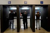 Gun owners fire their pistols at an indoor shooting range during a qualification course to rene ...