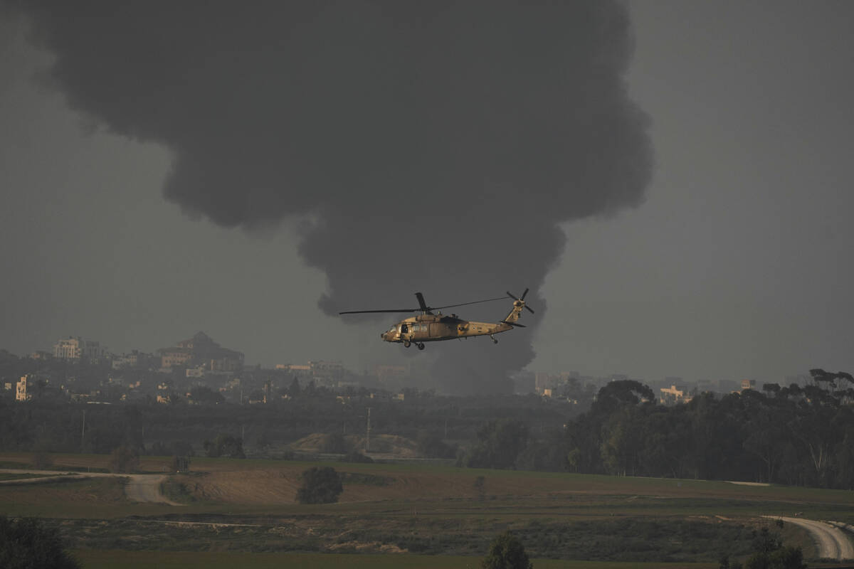 An Israeli military helicopter flies near the Israeli-Gaza border, as seen from southern Israel ...