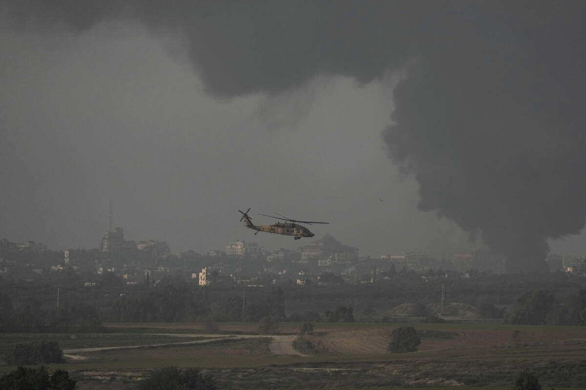 An Israeli military helicopter flies near the Israeli-Gaza border, as seen from southern Israel ...