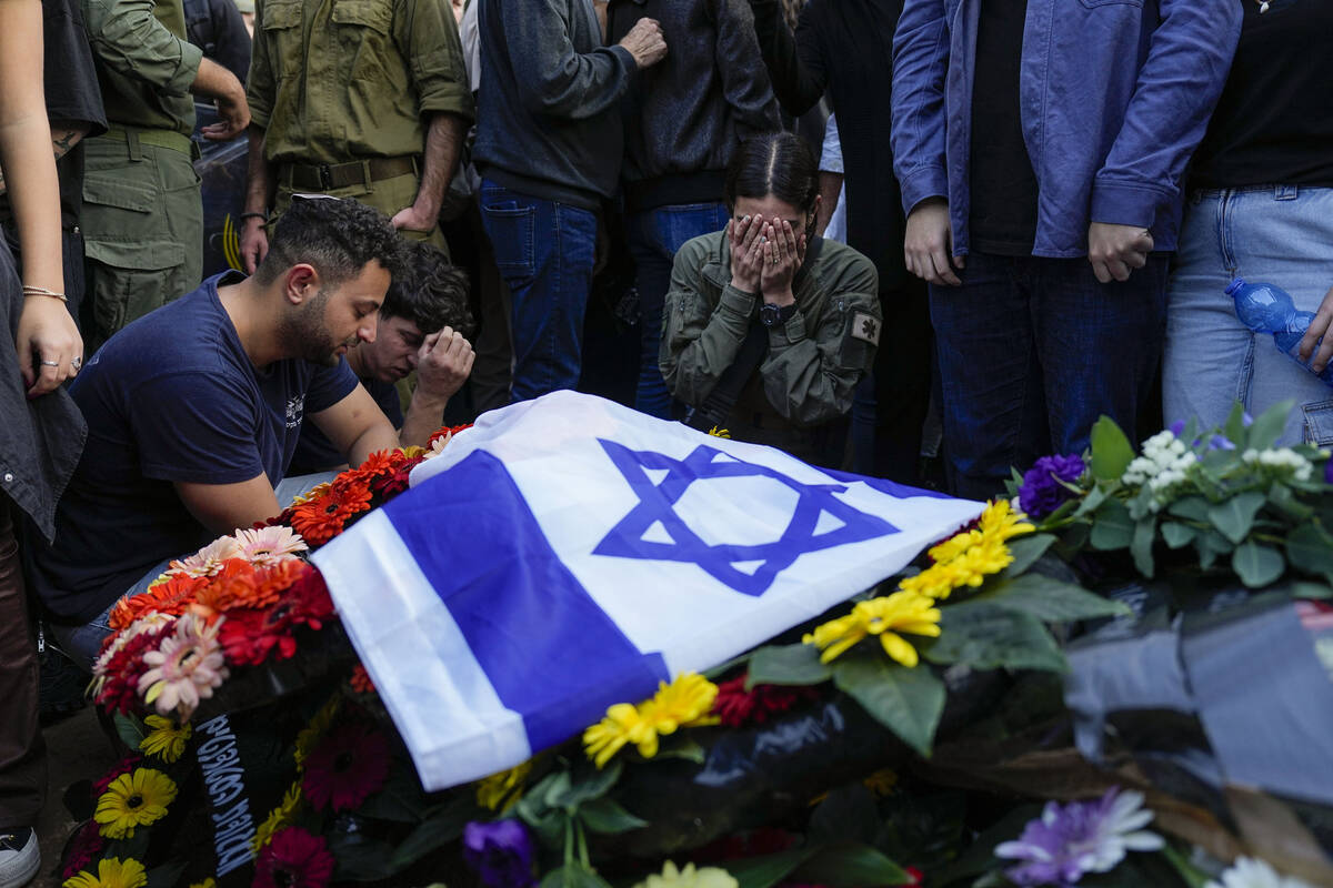 Mourners gather in grief around the grave of Israeli soldier Captain Harel Ittah during his fun ...