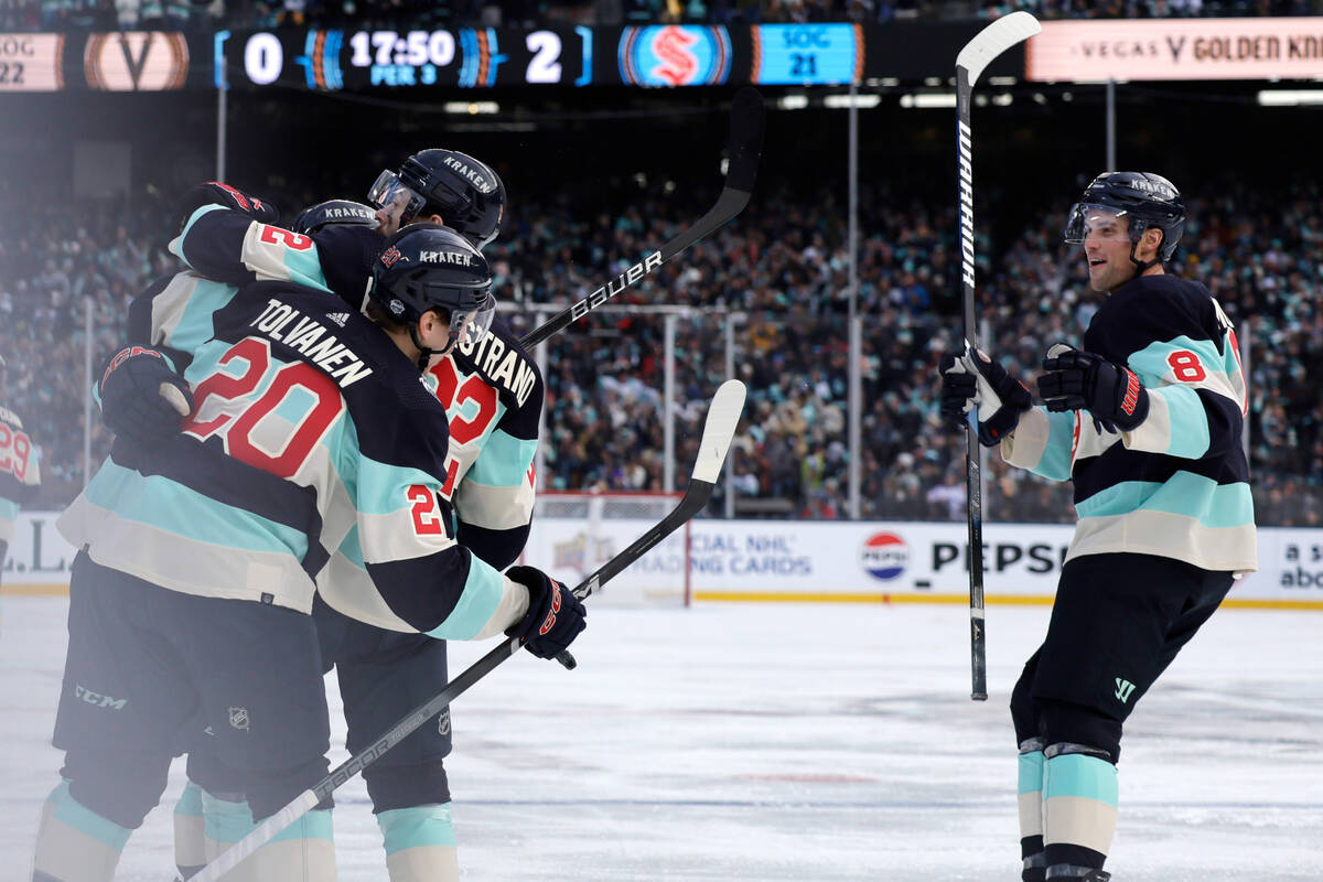 Seattle Kraken right wing Eeli Tolvanen (20) and right wing Oliver Bjorkstrand (22) hug center ...