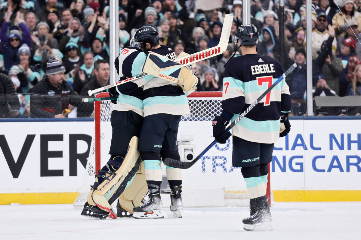 Seattle Kraken goaltender Joey Daccord (35) is hugged by defenseman Justin Schultz with right w ...